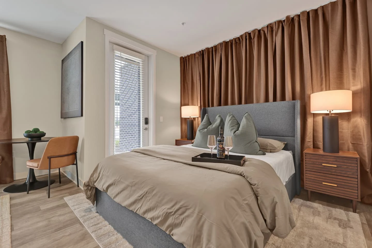 Warm copper curtains, softly lit bedside lamps, and a comfortably furnished bedroom at Modern Luxe